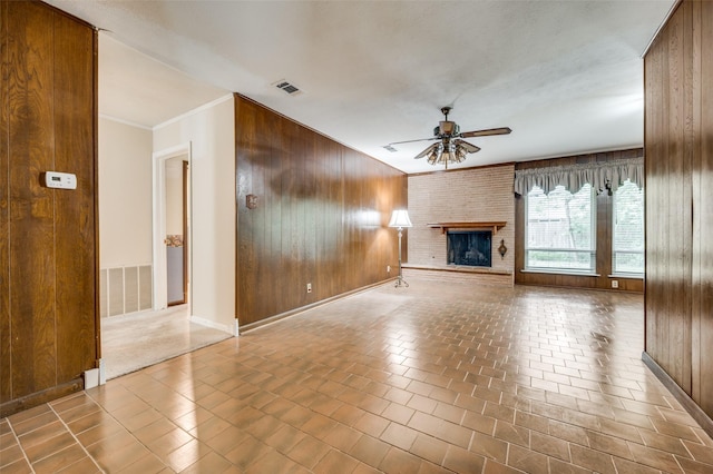 1122 Gloucester Ct N, Irving, TX 75062 - unfurnished living room featuring wooden walls, ceiling fan, baseboards, and a brick fireplace