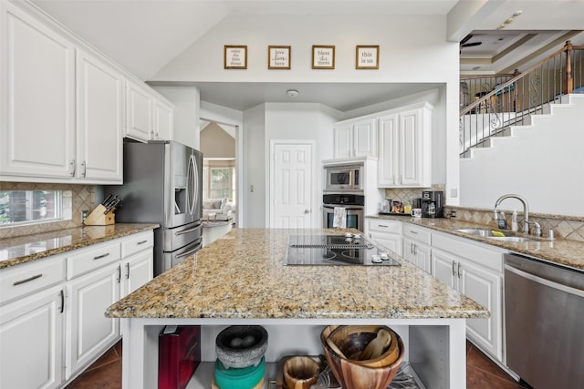 1908 Longfellow Ln, Flower Mound, TX 75028 - kitchen with stainless steel appliances, a sink, white cabinets, light stone countertops, and vaulted ceiling