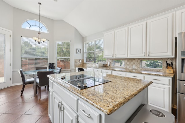 1908 Longfellow Ln, Flower Mound, TX 75028 - kitchen featuring black electric cooktop, plenty of natural light, tasteful backsplash, vaulted ceiling, and white cabinets