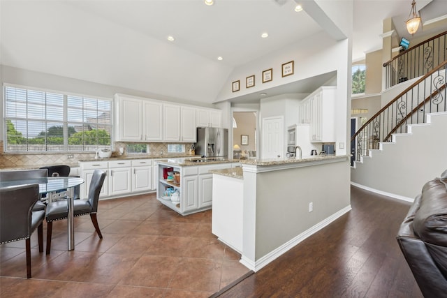 1908 Longfellow Ln, Flower Mound, TX 75028 - kitchen with white cabinetry, tasteful backsplash, stainless steel fridge with ice dispenser, high vaulted ceiling, and recessed lighting