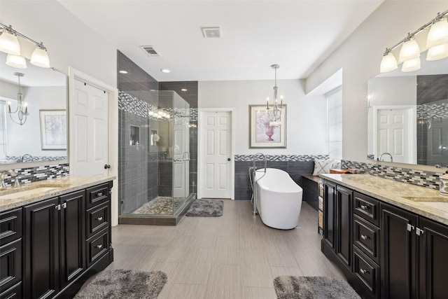 1908 Longfellow Ln, Flower Mound, TX 75028 - full bathroom with a chandelier, a shower stall, two vanities, a soaking tub, and tile walls