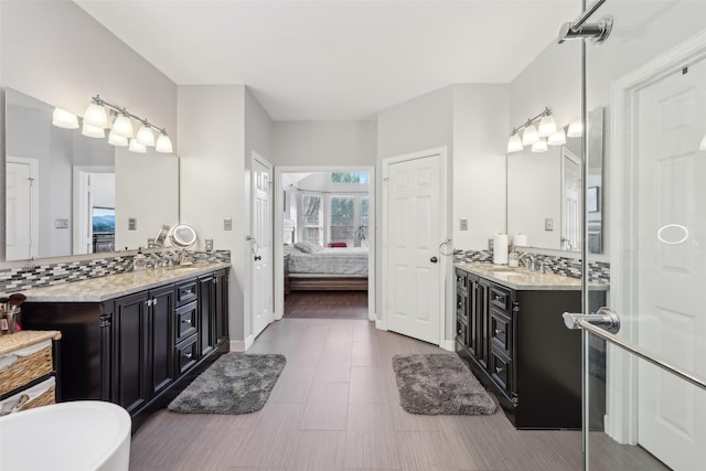 1908 Longfellow Ln, Flower Mound, TX 75028 - bathroom with ensuite bath, two vanities, a soaking tub, and baseboards