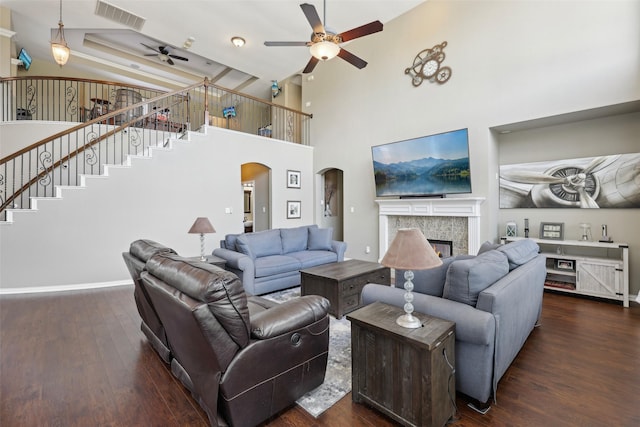1908 Longfellow Ln, Flower Mound, TX 75028 - living area with a ceiling fan, arched walkways, dark wood-type flooring, a high ceiling, and a tile fireplace