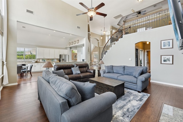 1908 Longfellow Ln, Flower Mound, TX 75028 - living room featuring arched walkways, ceiling fan, high vaulted ceiling, stairs, and dark wood-style floors