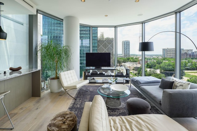 2900 Mckinnon St Unit 604, Dallas, TX 75201 - living room with floor to ceiling windows, light wood-style floors, and plenty of natural light