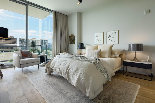 2900 Mckinnon St Unit 604, Dallas, TX 75201 - bedroom with a wall of windows, wood finished floors, a city view, and recessed lighting