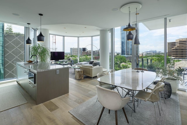2900 Mckinnon St Unit 604, Dallas, TX 75201 - dining space with light wood-style flooring and a wall of windows