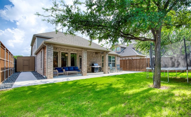 10140 Kingsland Trl, Mckinney, TX 75072 - back of property featuring a trampoline, an outdoor hangout area, brick siding, a patio, and a shingled roof
