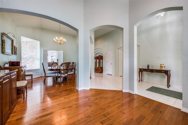 2925 Custer Dr, Corinth, TX 76210 - living room with light wood-type flooring, a high ceiling, a chandelier, and baseboards