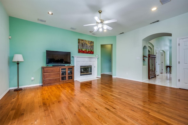 2925 Custer Dr, Corinth, TX 76210 - unfurnished living room with ceiling fan, hardwood / wood-style floors, arched walkways, a fireplace, and baseboards