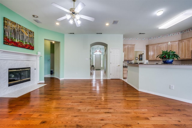 2925 Custer Dr, Corinth, TX 76210 - unfurnished living room with arched walkways, ceiling fan, light wood-type flooring, recessed lighting, and a high end fireplace