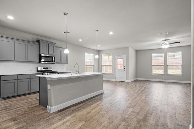 825 Blackhorse Trl, Fort Worth, TX 76247 - kitchen with appliances with stainless steel finishes, gray cabinetry, a sink, light wood-style flooring, and recessed lighting