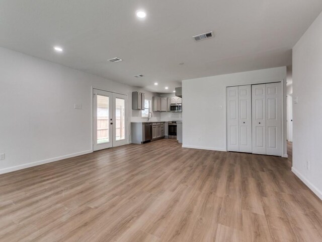 2032 Meadfoot Rd, Carrollton, TX 75007 - unfurnished living room with light wood-type flooring, recessed lighting, baseboards, and a sink