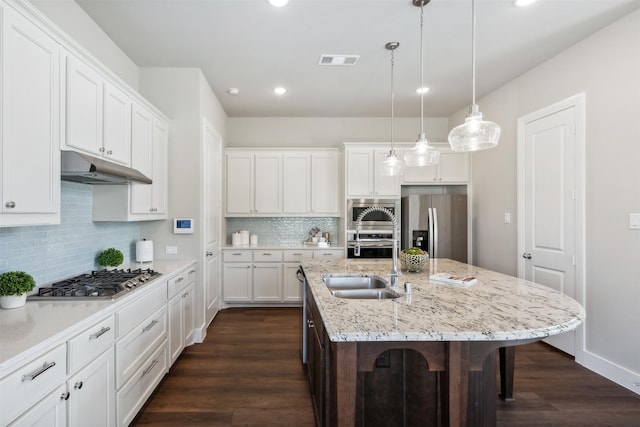 14436 Greymoore Cir, Fort Worth, TX 76008 - kitchen featuring stainless steel appliances, under cabinet range hood, a sink, dark wood-style floors, and a breakfast bar