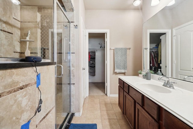 14709 Crystal Lake Dr, Little Elm, TX 75068 - bathroom featuring vanity, a walk in closet, a shower stall, and tile patterned flooring