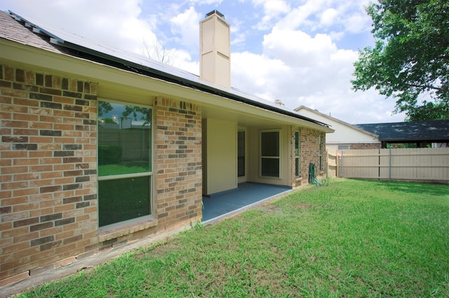 4136 Periwinkle Dr, Fort Worth, TX 76137 - back of property with brick siding, solar panels, a patio area, and a chimney