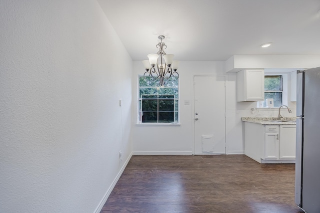 1206 Curtis Dr, Garland, TX 75040 - unfurnished dining area featuring a chandelier, a sink, healthy amount of natural light, and dark wood-style floors