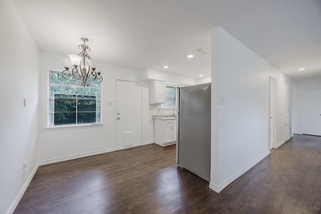 1206 Curtis Dr, Garland, TX 75040 - kitchen with freestanding refrigerator, dark wood-style flooring, a chandelier, light countertops, and white cabinetry