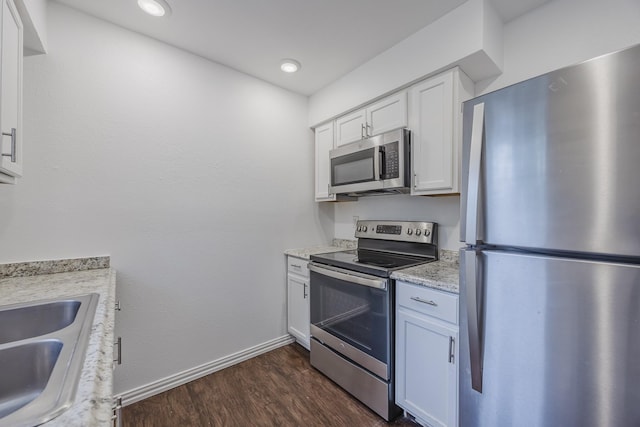 1206 Curtis Dr, Garland, TX 75040 - kitchen with stainless steel appliances, baseboards, dark wood-type flooring, white cabinetry, and a sink