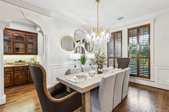 1516 Hawthorne Ln, Keller, TX 76262 - dining space featuring a chandelier, ornamental molding, wood finished floors, a decorative wall, and decorative columns