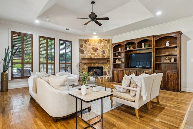 1516 Hawthorne Ln, Keller, TX 76262 - living area with light wood-style floors, ceiling fan, crown molding, a stone fireplace, and a raised ceiling