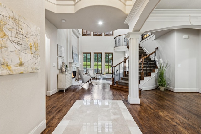 1516 Hawthorne Ln, Keller, TX 76262 - entrance foyer featuring a towering ceiling, stairs, wood finished floors, ornamental molding, and a warm lit fireplace