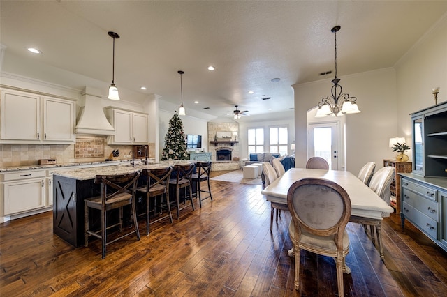 312 Spring Run Dr, Decatur, TX 76234 - dining area with dark wood finished floors, ceiling fan, a stone fireplace, recessed lighting, and ornamental molding