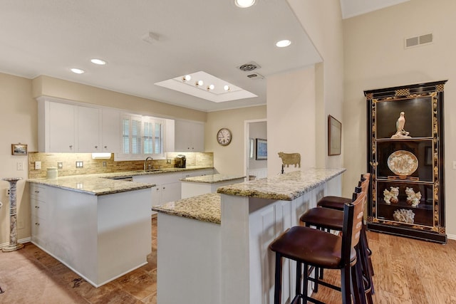 2414 Meadows Ln, Sherman, TX 75092 - kitchen featuring a peninsula, a sink, white cabinets, and recessed lighting