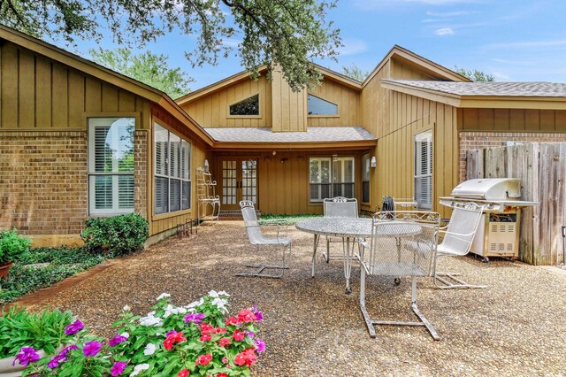 2414 Meadows Ln, Sherman, TX 75092 - rear view of house with a patio, outdoor dining area, french doors, roof with shingles, and brick siding