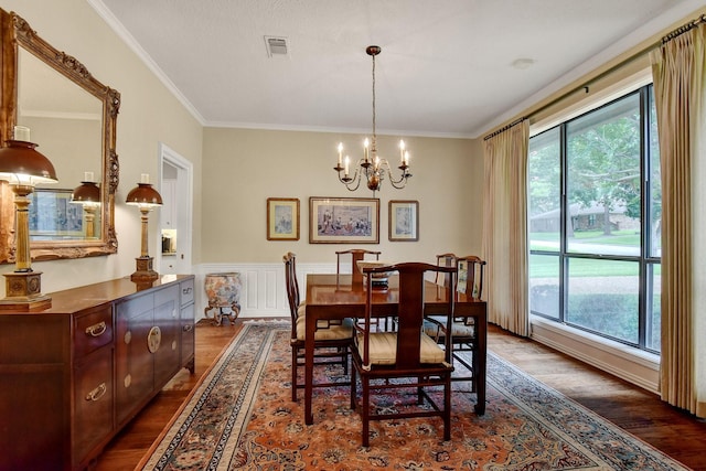 2414 Meadows Ln, Sherman, TX 75092 - dining area with plenty of natural light, dark wood-type flooring, a chandelier, crown molding, and a wainscoted wall