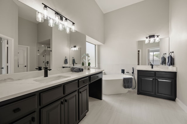 850 White River Dr, Prosper, TX 75078 - full bathroom featuring two vanities, a stall shower, a freestanding tub, and high vaulted ceiling