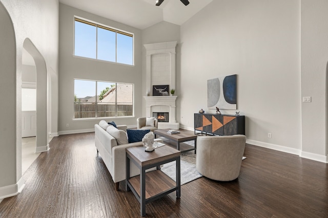 850 White River Dr, Prosper, TX 75078 - living room featuring high vaulted ceiling, ceiling fan, dark wood-type flooring, arched walkways, and a glass covered fireplace