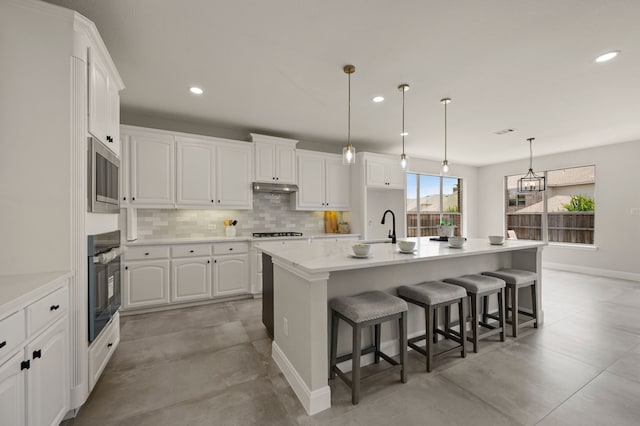 850 White River Dr, Prosper, TX 75078 - kitchen with oven, under cabinet range hood, white cabinets, recessed lighting, and cooktop