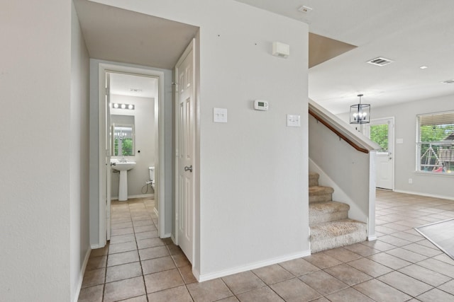 6128 Redear Dr, Fort Worth, TX 76179 - stairway featuring tile patterned flooring, a chandelier, and baseboards
