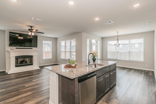 2028 Proteus Dr, Haslet, TX 76052 - kitchen with stainless steel dishwasher, a sink, dark wood finished floors, a fireplace with raised hearth, and open floor plan
