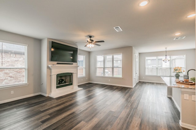 2028 Proteus Dr, Haslet, TX 76052 - unfurnished living room with plenty of natural light, a ceiling fan, a fireplace with raised hearth, a chandelier, and recessed lighting