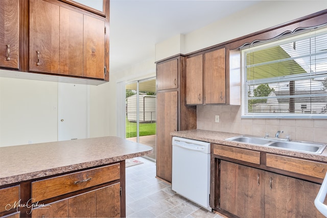 3425 Ponderosa Dr, Bossier City, LA 71112 - kitchen featuring white dishwasher, a sink, decorative backsplash, and light countertops