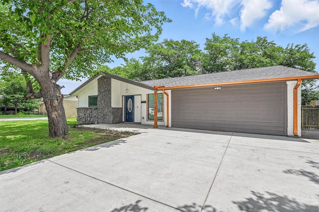 2614 E Mitchell St, Arlington, TX 76010 - mid-century inspired home with stone siding, concrete driveway, a garage, and a front yard