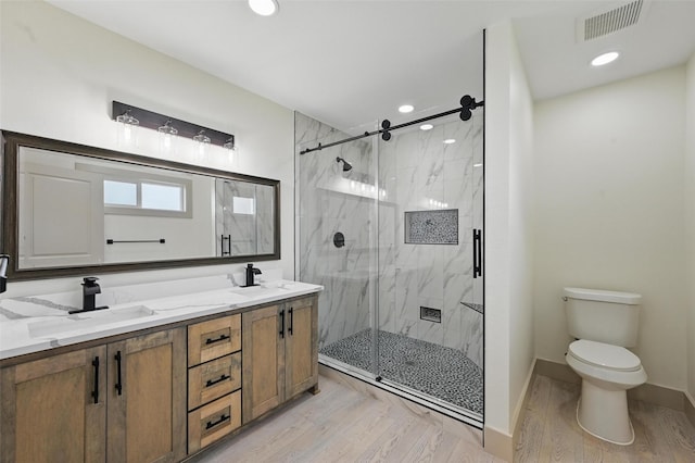 2614 E Mitchell St, Arlington, TX 76010 - bathroom with a marble finish shower, wood finished floors, toilet, double vanity, and baseboards