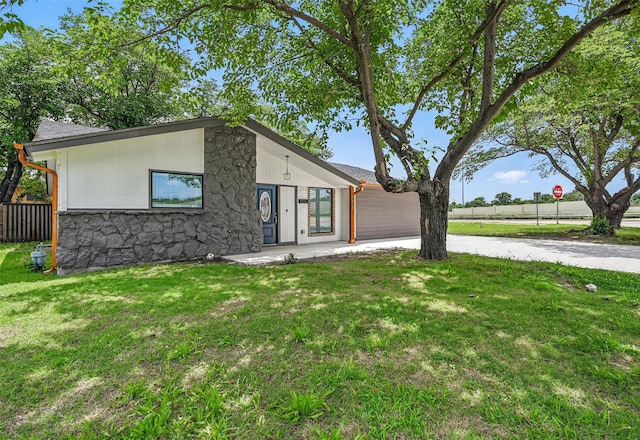 2614 E Mitchell St, Arlington, TX 76010 - mid-century inspired home featuring concrete driveway, a front yard, an attached garage, and stone siding