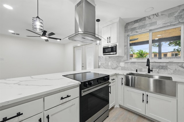 2614 E Mitchell St, Arlington, TX 76010 - kitchen with island exhaust hood, black range with electric cooktop, stainless steel microwave, a sink, and ceiling fan