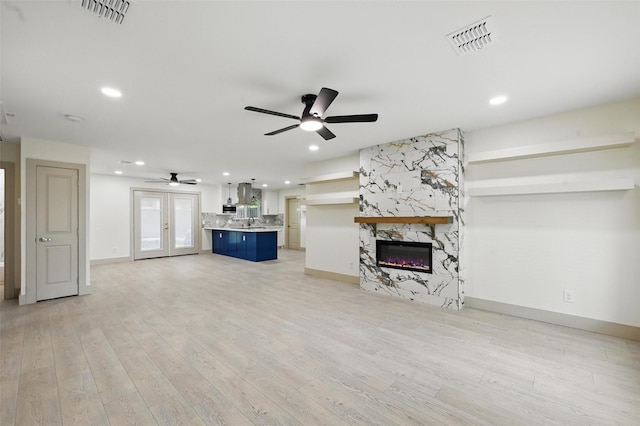 2614 E Mitchell St, Arlington, TX 76010 - unfurnished living room featuring a ceiling fan, baseboards, a premium fireplace, light wood-style floors, and recessed lighting