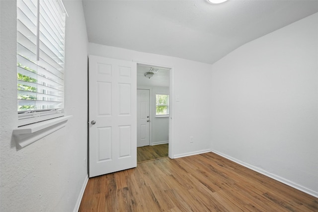 210 N 5th Ave, Denison, TX 75021 - unfurnished bedroom featuring baseboards, wood finished floors, and lofted ceiling