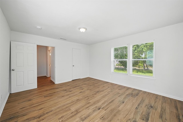 210 N 5th Ave, Denison, TX 75021 - unfurnished bedroom with wood finished floors, baseboards, and a closet