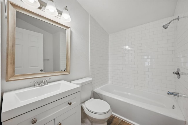 210 N 5th Ave, Denison, TX 75021 - bathroom featuring toilet, wood finished floors, vaulted ceiling, vanity, and bathtub / shower combination