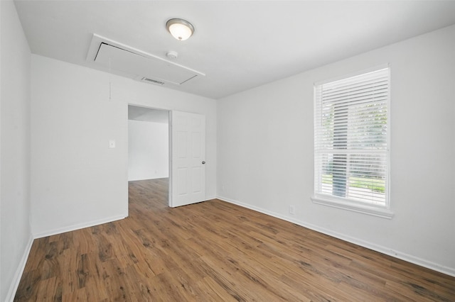 210 N 5th Ave, Denison, TX 75021 - unfurnished room with attic access, healthy amount of natural light, and wood finished floors