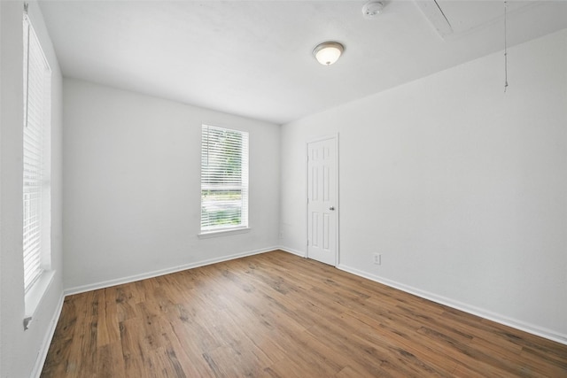 210 N 5th Ave, Denison, TX 75021 - spare room featuring attic access, wood finished floors, baseboards, and a smoke detector