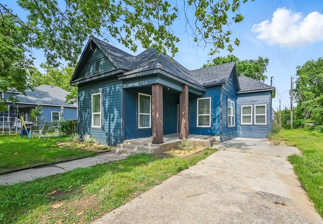 210 N 5th Ave, Denison, TX 75021 - view of front of property with covered porch, a shingled roof, and concrete driveway
