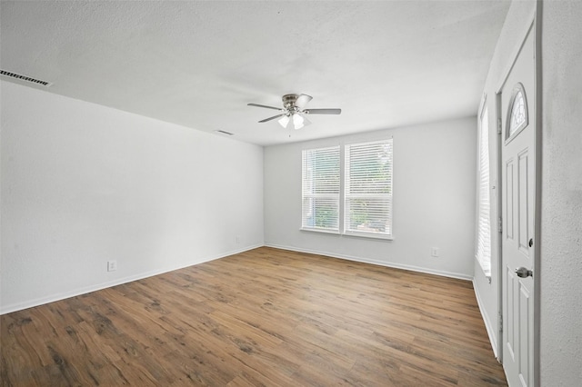 210 N 5th Ave, Denison, TX 75021 - unfurnished bedroom featuring wood finished floors, baseboards, and a ceiling fan