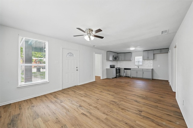 210 N 5th Ave, Denison, TX 75021 - unfurnished living room with ceiling fan, wood finished floors, and baseboards